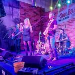 Image of Champagne Lipsmack performing at Soulbelly BBQ against a purple background.